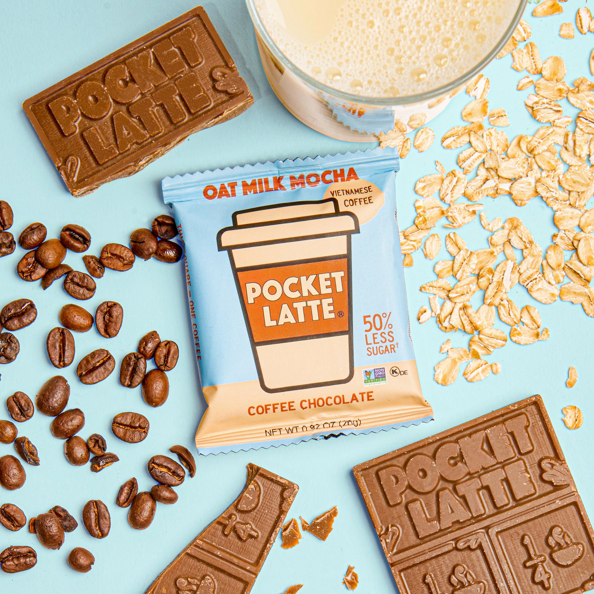 A Pocket Latte Oat Milk Mocha coffee chocolate bar with coffee beans, chocolate pieces, oats, and a glass of oat milk