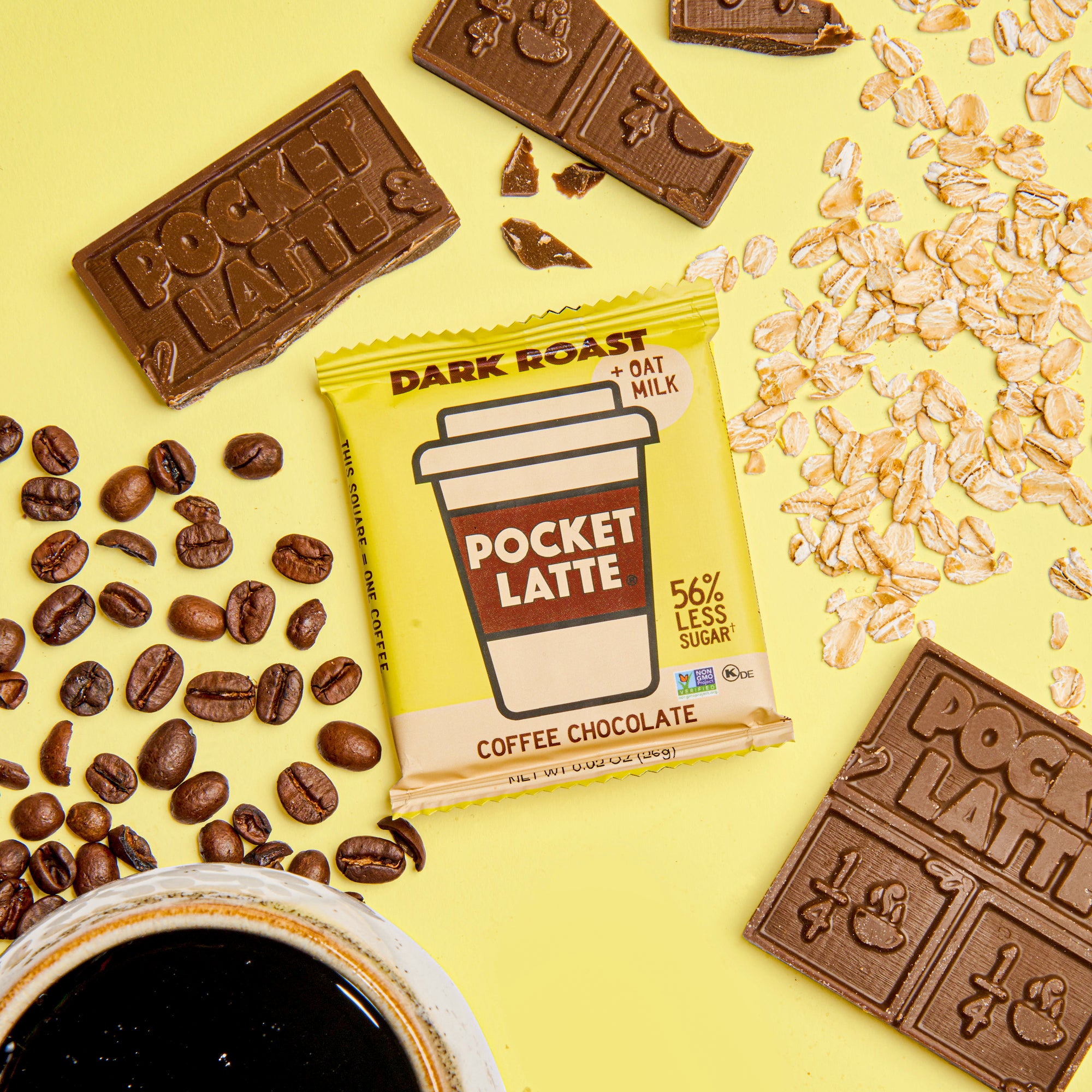 A Pocket Latte Dark Roast coffee chocolate bar surrounded by coffee beans, chocolate pieces and oats